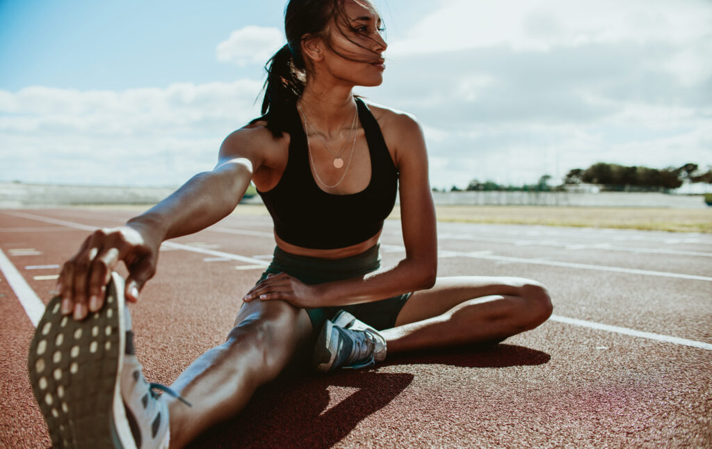 Runner stretching on track during run