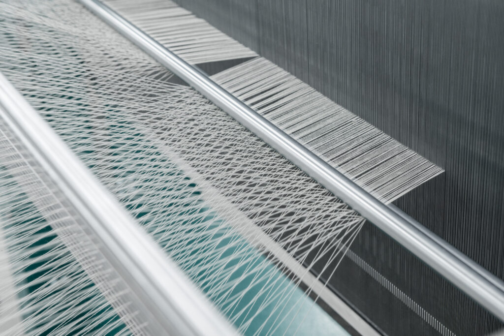 Close-up of intricate weaving threads on a loom.