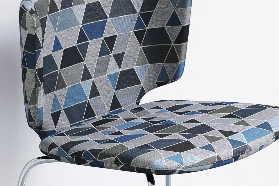 A modern chair with a geometric-patterned fabric in shades of blue, gray, and black.