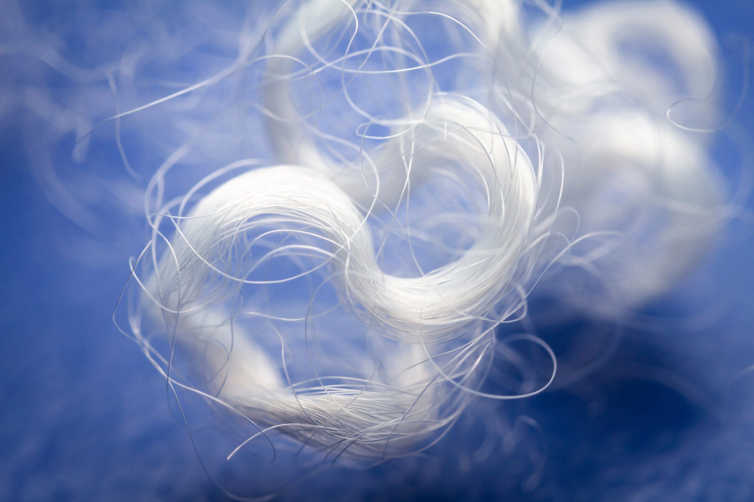 Bundles of shiny white threads neatly rolled and stacked